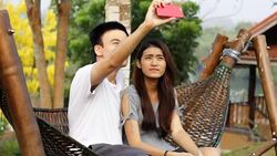 Smiling couple taking selfie on their phone in a park Stock Footage