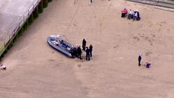 Aerials: Officials inspect dinghy - Group of migrants rescued from sinking inflatable boat in the English Channel News Clip