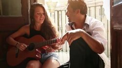 She plays guitar and sing for him Stock Footage