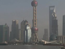Ships and barges sail past the skyscrapers of downtown Shanghai, Pudong, China Stock Footage