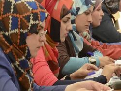 AID workers in head scarves process Syrian Civil War refugees Stock Footage