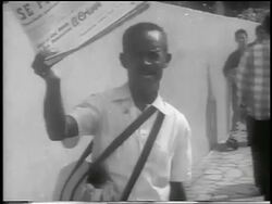 B/W 1959 tilt up man holding newspaper with revolution headline / Havana / newsreel Stock Footage