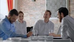 Restaurant employees crack up laughing in staff business meeting Stock Footage