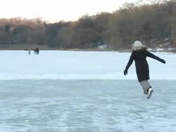 MS TS Young lady wearing winter cloths and skating around in circle on frozen lake in High Park / Toronto, Ontario, Canada  Stock Footage