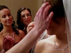 Bridesmaid and mother adjusts brides hair as she smiles at camera Stock Footage