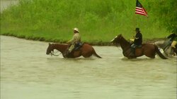 General Custer and soldiers from American 7th cavalry riding horses across river Stock Footage