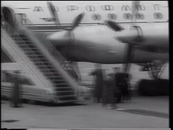 B/W 1961 Yuri Gagarin (first man in space) descending stairs from airliner + walking on carpet Stock Footage