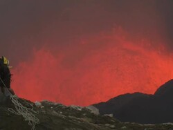 Climber tackles a cliff overhead erupting volcano crater, Marum Volcano, Ambrym Island, Vanuatu Stock Footage
