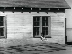 B/W 1936 PAN young girl carrying bucket past house to cart in Dust Bowl / Oklahoma Stock Footage