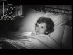 Preparation for bed. Child lays in bed while old man sleeps on the floor. France, 1960 Stock Footage