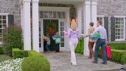 Family arrives at grandma's house for Christmas, grandma answers door and welcomes family with hugs (dolly-shot) Stock Footage