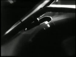 A man attaches a cylinder to a Victrola and moves the horn into position for listening in a 1890s reenactment. News Clip