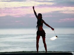 MS ZO Woman poi dancer performing in front of pool with reflection of his silhouette in pool at sunrise / Montezuma, Costa Rica Stock Footage