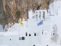 MS AERIAL Shot of man ringing bell in monastery at wall of rock / Amorgos, Cyclades, Greece Stock Footage
