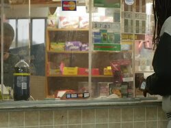 Man buys soda from behind safety glass Stock Footage