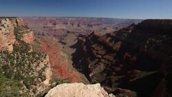 Scenic overlook of Grand Canyon peaking over the rim to the deep valley below Stock Footage