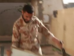 Fall Of Sirte - Rebel Shoots Gaddafi's Portrait News Clip