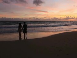 Good Looking Young Couple walking by the Sea at Sunset Stock Footage