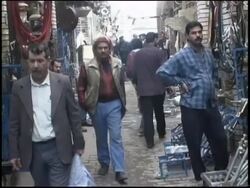 2003 MONTAGE Pre-war Iraq / WS MS Street market scenes / MS Man trying on keffiyeh / Iraq  Stock Footage