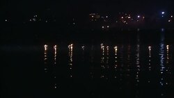 A river reflects the multicolored lights and floating diyas during a Diwali celebration in India. Stock Footage