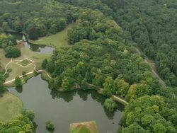 MS AERIAL ZO Shot of pyramid middle of lake with surrounded by trees near Schloss Branitz / Germany Stock Footage