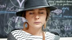 Close up shot of an elegant young business woman standing in front of a black board filled with scribbles and looking at camera Stock Footage