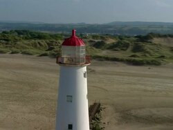 AERIAL, ZO, CIRCLING, Lighthouse on beach, Denbighshire, England Stock Footage