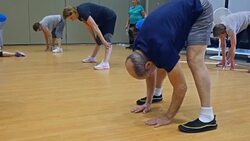 Flexible senior man stretches in exercise class Stock Footage