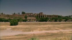 Pedestrians cross a field in the Circus Maximus in Rome, Italy. Stock Footage