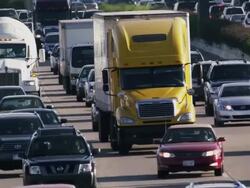 Long lens, overhead, huge traffic congestion drives toward and passes under bridge on hot interstate highway. Stock Footage