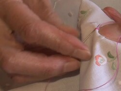 Old woman patiently embroidering Stock Footage