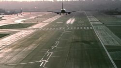 airliner passenger jet landing at major airport in late afternoon light casting long shadows Stock Footage