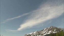 White clouds streak above snow-dusted peaks in Alaska. Stock Footage