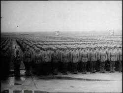 Chaing Kai Shek salutes a mass of Chinese Nationalist standing at attention who then march away with their weapons. News Clip