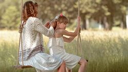 SLO MO Mother braiding daughters hair on a swing Stock Footage