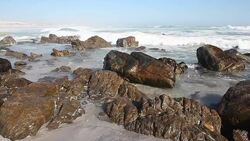 Waves on the beack breaking over the rocks Stock Footage