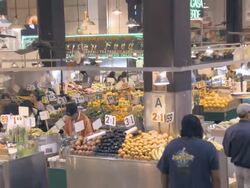 ZO from fruit and vegetable stands to WS of historic Grand Central Market on ground floor of Homer Laughlin Building /Los Angeles, California, USA Stock Footage