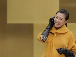 MS Young woman in yellow coat talking on mobile phone / China Stock Footage