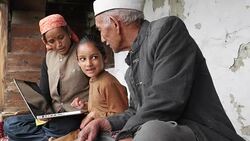 Young girl with her grandparents, grand father asking her questions about the laptop Stock Footage
