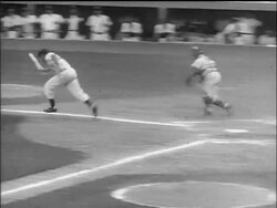 B/W 1955 PAN man pitching ball, batter hitting + running to first base, out / pitcher is mobbed Stock Footage