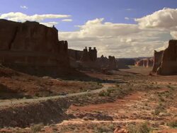 Panoramic view of Arches National Park with tourist cars driving in distance - zoom in towards cars Stock Footage