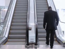  WS Businessman ascending escalator in office building / Seattle, Washington, United States Stock Footage