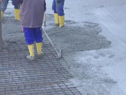 Workers Directing Concrete Onto The Construction Site Stock Footage