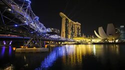 Bright, neon lights and lasers illuminate Heiix Bridge and the buildings of the Marina Bay Sands. Stock Footage