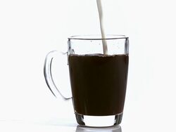 CU SLO MO Milk being poured in cup of coffee / Vieux Pont, Normandy, France  Stock Footage