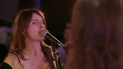Female folk singers strum acoustic guitars and perform for crowd at live music showcase Stock Footage