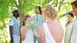 Bride playfully rubbing bouquet in flower girlsï¿½ face at wedding reception Stock Footage