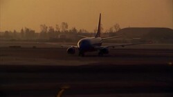 PAN, ZI airplane taxiing on runway at dusk Stock Footage