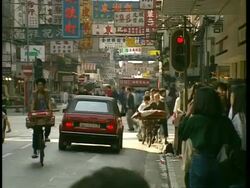 WA Busy city street scene showing people, signs and traffic, Hong Kong Stock Footage