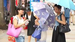 People in busy Shenzhen city centre on phones News Clip